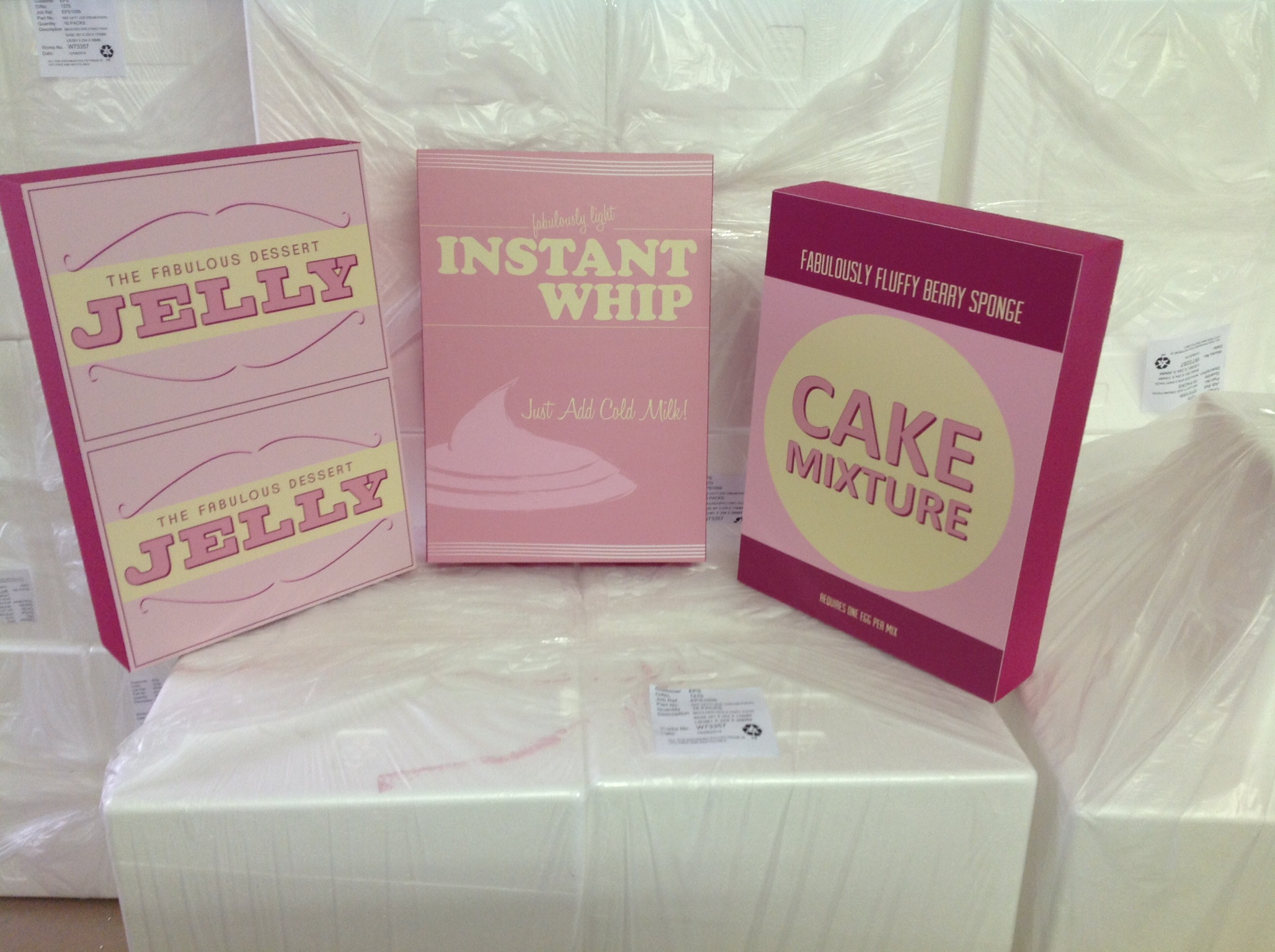 Polystyrene food props labeled JELLY, INSTANT WHIP, and BERRY SPONGE CAKE staged in workshop